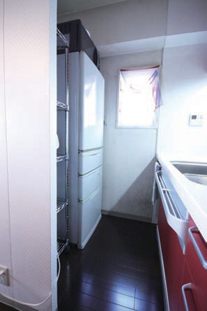 目隠し間仕切りの中に冷蔵庫と収納ラックを設置。
