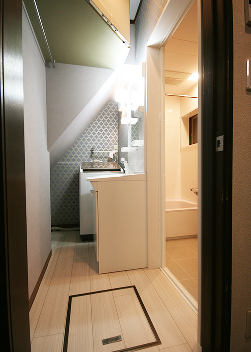 洗面化粧台や吊戸棚はそのままに、床と壁を貼替えた洗面室浴室入口との段差を解消。